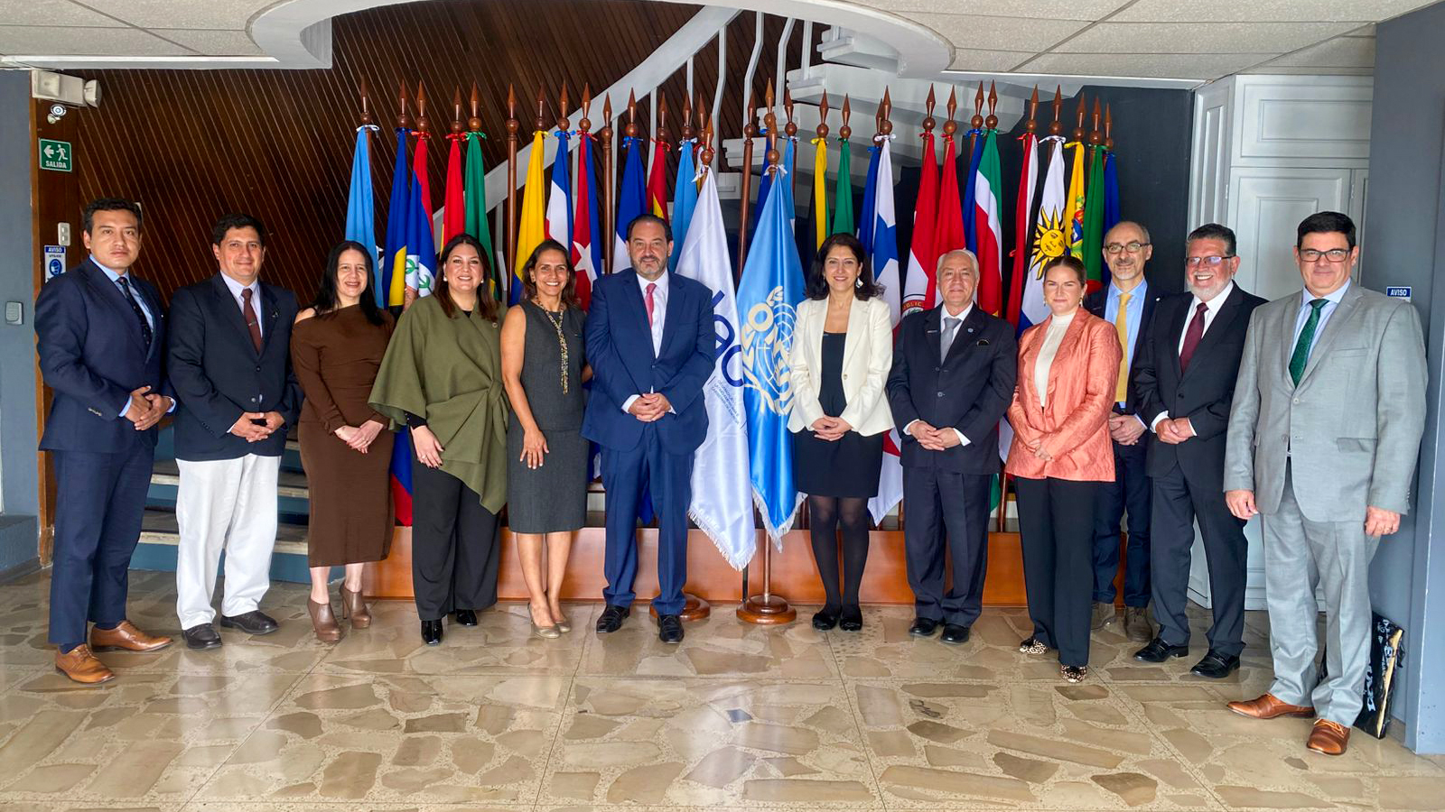 Entities' managers pose in front of their country's flags during the signed cooperation framework event.